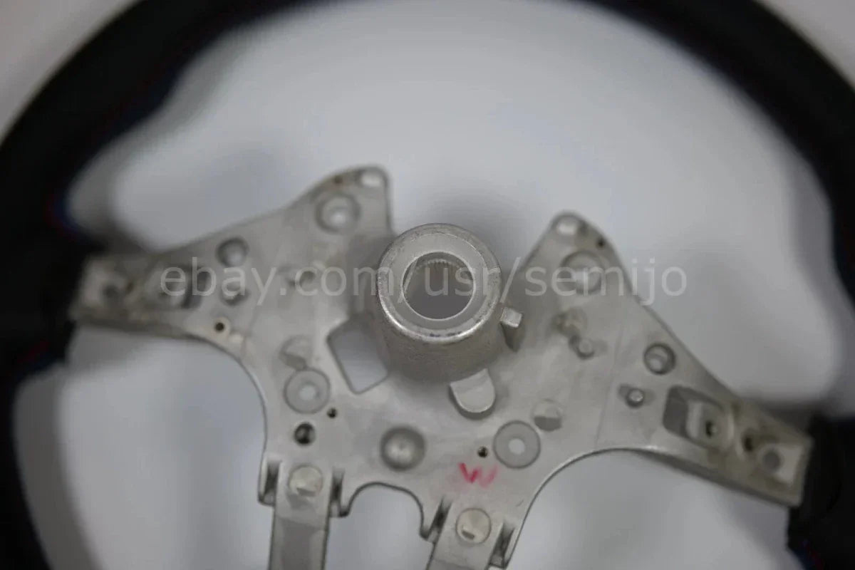 Close-up of BMW F Series M Sport steering wheel metal frame, circular mount center