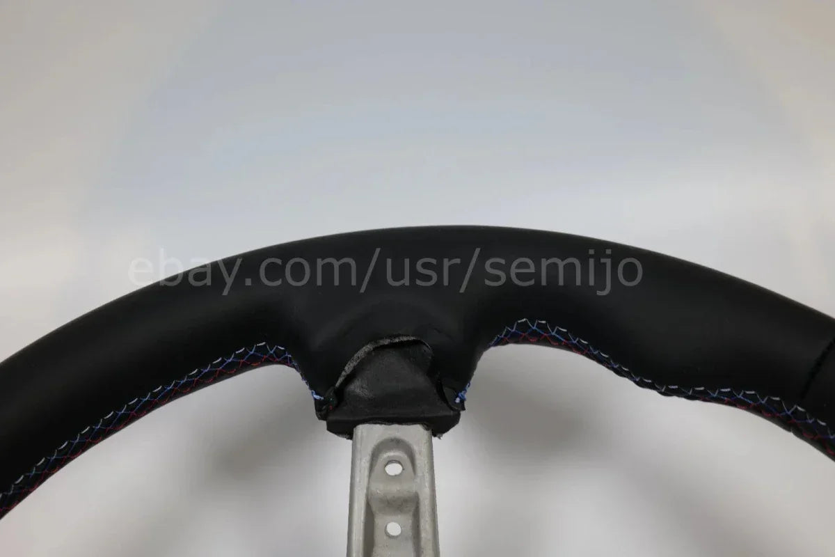 Close-up of BMW F Series M Sport steering wheel with multicolor stitching detail