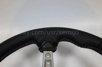 Close-up of BMW F Series M Sport steering wheel with multicolor stitching detail