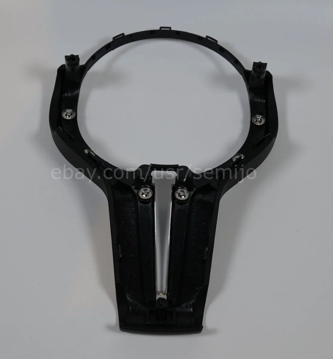 Black steering wheel front cover trim for BMW F Series M Sport, viewed from above.