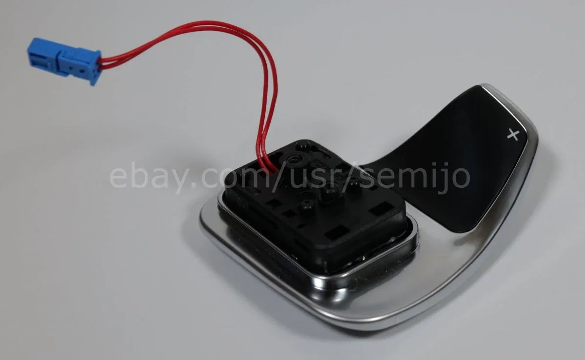 BMW F Series steering wheel paddle shifter with wiring and silver trim on white background