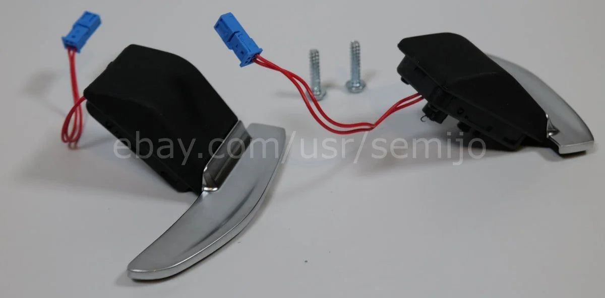 Silver steering wheel paddle shifters for BMW F Series with wiring and screws on white background