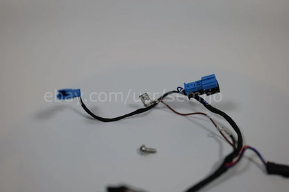 BMW F Series steering wheel wiring cable with blue connectors and screw on white background